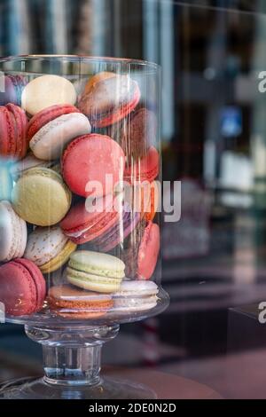 Macarons dans un pot en verre. Assortiment français de friandises délicates colorées, vertical. Présentoir à vitrine de la boutique de bonbons Banque D'Images