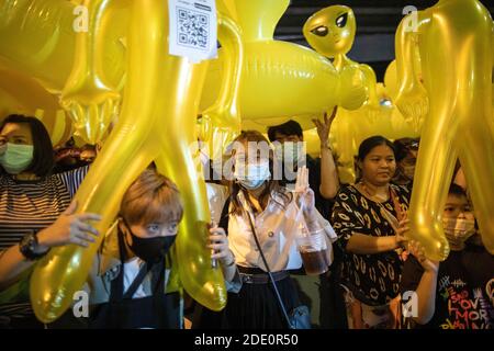 Bangkok, Thaïlande. 27 novembre 2020. Un manifestant pro-démocratie salue les trois doigts tout en tenant des figures gonflables lors d'une manifestation anti-gouvernementale dans la capitale thaïlandaise. Des milliers de manifestants pro-démocratie ont organisé une manifestation appelée « exercice de répétition du coup d'État » à l'intersection de Lad Phrao pour demander la démission du Premier ministre thaïlandais et la réforme de la monarchie. Crédit : SOPA Images Limited/Alamy Live News Banque D'Images