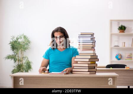 Jeune étudiant et beaucoup de livres dans le salle de classe Banque D'Images