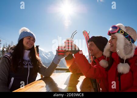 Groupe d'amis appréciant le vin chaud chaud au café de la station de ski. Banque D'Images