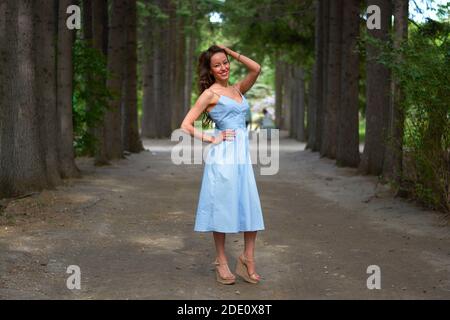 Une fille vêque d'une robe bleue marche dans le parc Banque D'Images