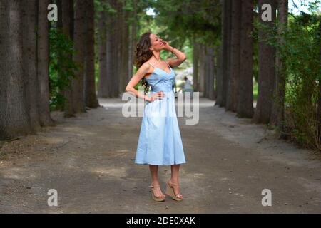 Une fille vêque d'une robe bleue marche dans le parc Banque D'Images
