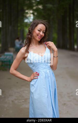 Une fille vêque d'une robe bleue marche dans le parc Banque D'Images