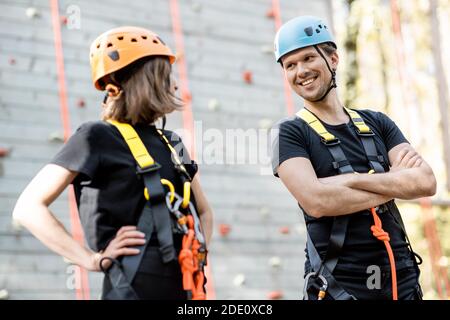 Portrait d'un couple actif bien équipé prêt à monter le mur à l'extérieur du parc d'attractions Banque D'Images