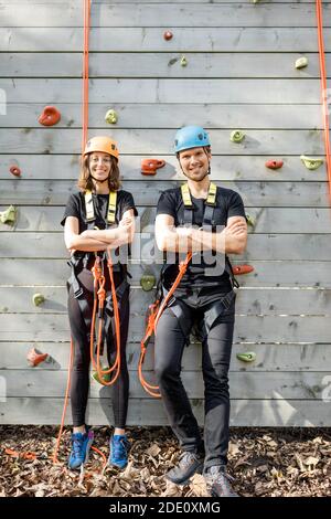 Portrait d'un couple actif bien équipé prêt à monter le mur à l'extérieur du parc d'attractions Banque D'Images