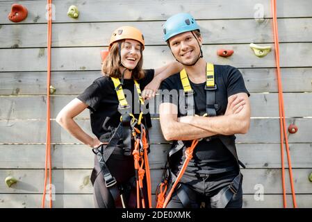 Portrait d'un couple actif bien équipé prêt à monter le mur à l'extérieur du parc d'attractions Banque D'Images