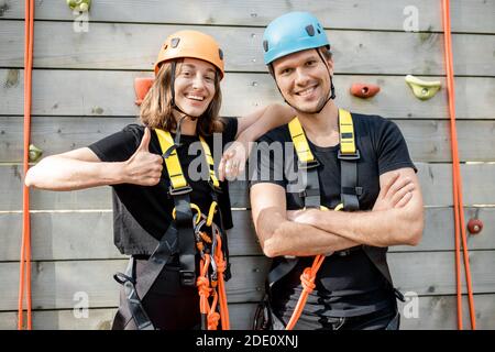 Portrait d'un couple actif bien équipé prêt à monter le mur à l'extérieur du parc d'attractions Banque D'Images