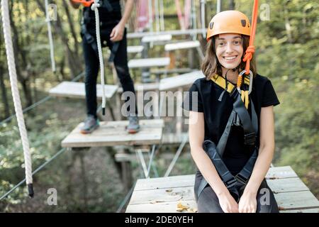 Portrait d'une jeune femme bien équipée ayant une activité de loisirs dans un parc de corde Banque D'Images