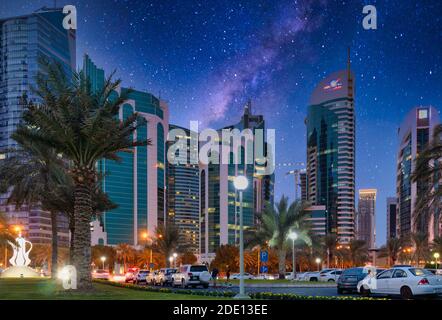 Doha Qatar Skyline la nuit du parc Sheraton avec des voitures, des gens dans la rue et des étoiles dans le ciel Banque D'Images