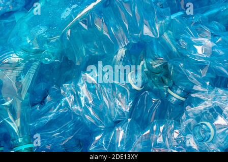 Bouteilles en plastique écrasées sur fond bleu. Un symbole de la pollution de l'environnement et des défis et des succès de recyclage Banque D'Images