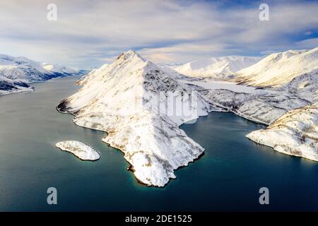 Vue aérienne des montagnes enneigées le long des eaux claires de l'Altafjord, du comté de Troms og Finnmark, du nord de la Norvège, de la Scandinavie et de l'Europe Banque D'Images