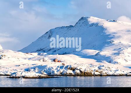 Soleil d'hiver sur des cabanes de pêcheurs isolées dans la neige, Hasvik, Soroya Island, Troms og Finnmark, Arctique, Norvège du Nord, Scandinavie, Europe Banque D'Images