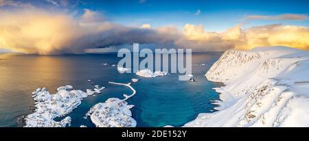 Ciel brûlant au lever du soleil au-dessus de la mer froide et village de Sorvaer couvert de neige, île de Soroya, Hasvik, Troms og Finnmark, Arctique, Norvège Banque D'Images