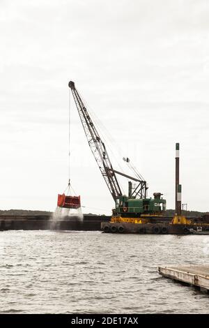 Welfleet Harbour est en train d'être dragué avec une grue flottante à Wellfleet, Massachusetts. Banque D'Images