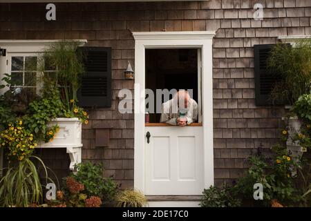 Un homme se classe dans la rue à partir d'une demi-porte à Provincetown, Massachusetts. Banque D'Images