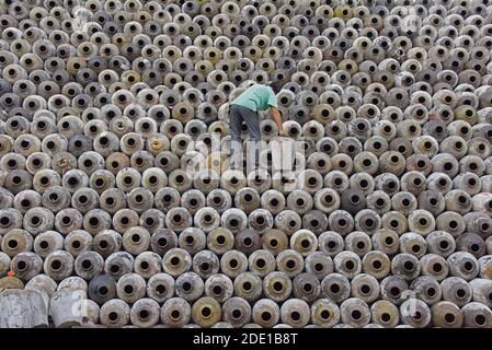 Homme empilant des pots de vin sur la grande pile dans un domaine viticole, Linhai, province de Zhejiang, Chine Banque D'Images