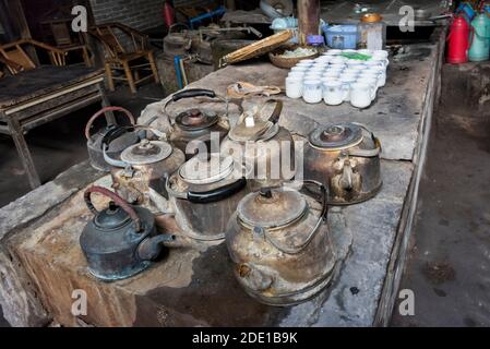 Bouilloires de thé sur le poêle dans une ancienne maison de thé, Pengzhen, Chengdu, province du Sichuan, Chine Banque D'Images