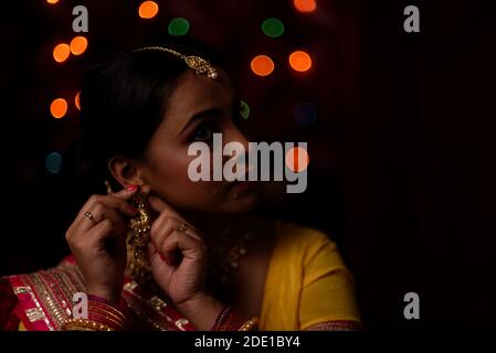 Portrait d'une femme bengali indienne magnifique brunette devant le fond bokeh lumineux coloré dans la soirée de Diwali. Style de vie indien Banque D'Images