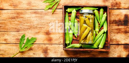 Gousses d'okra en conserve dans un pot en verre. Légumes salés marinés faits maison. Banque D'Images