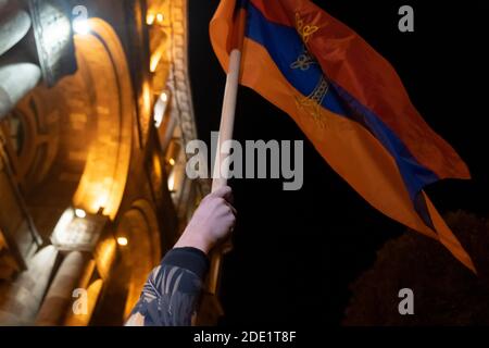 EREVAN, ARMÉNIE - NOVEMBRE 10 : un homme porte le drapeau arménien devant la résidence officielle du Premier ministre d'Arménie dans la ville d'Erevan, capitale de l'Arménie Banque D'Images