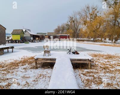 Jetée de pêche abandonnée sur un lac gelé. Vue sur le célèbre village flottant en hiver. Bokod, Hongrie. Banque D'Images