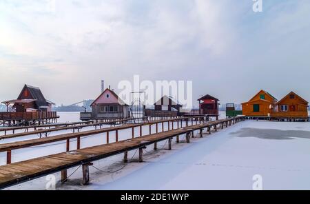 Vue sur le célèbre village flottant en hiver.Lac gelé, paysage enneigé. Bokod, Hongrie. Banque D'Images