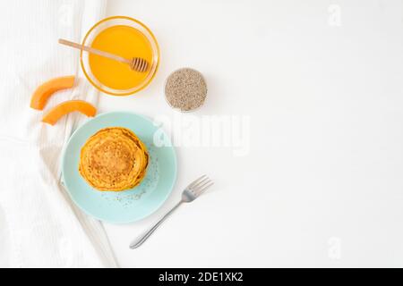 Une pile de crêpes de citrouille d'automne avec des graines de Chia et du miel sur un fond clair. Délicieux régime végétarien sain petit déjeuner. Le concept de prendre Banque D'Images