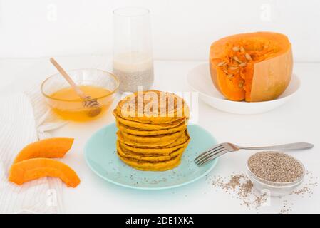 Une pile de crêpes de citrouille d'automne avec des graines de Chia et du miel sur un fond clair. Délicieux régime végétarien sain petit déjeuner. Le concept de prendre Banque D'Images