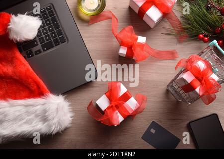 Arrière-plan conceptuel de Noël d'Internet avec ordinateur portable, carte, panier et cadeaux. Vue de dessus. Composition horizontale. Banque D'Images