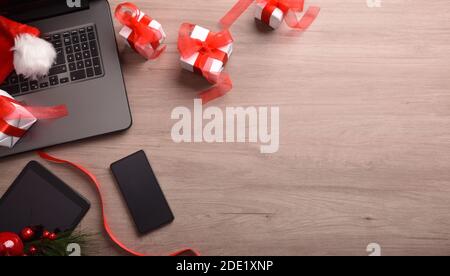 Arrière-plan de noël sur Internet avec ordinateur portable, carte, panier et cadeaux. Vue de dessus. Composition horizontale. Banque D'Images