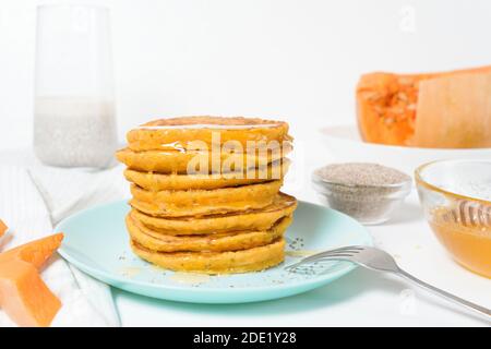 Une pile de crêpes de citrouille d'automne avec des graines de Chia et du miel sur un fond clair. Délicieux régime végétarien sain petit déjeuner. Le concept de prendre Banque D'Images