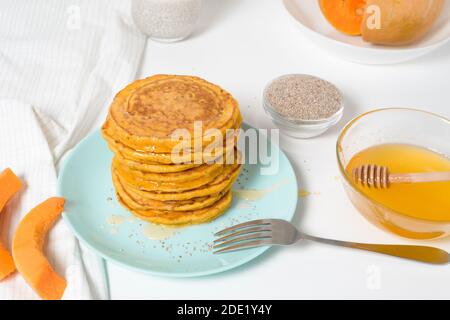 Une pile de crêpes de citrouille d'automne avec des graines de Chia et du miel sur un fond clair. Délicieux régime végétarien sain petit déjeuner. Le concept de prendre Banque D'Images