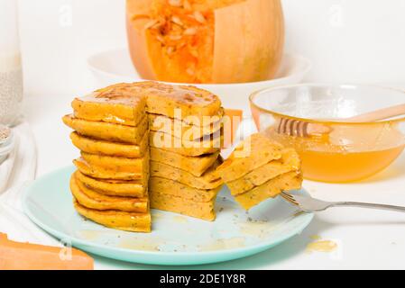 Une pile de crêpes de citrouille d'automne avec des graines de Chia et du miel sur un fond clair. Délicieux régime végétarien sain petit déjeuner. Le concept de prendre Banque D'Images