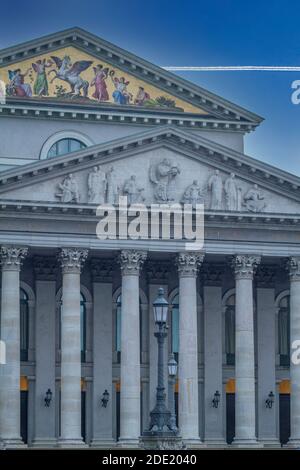 Gros plan sur le devant du Théâtre national, à Max-Joseph-Platz, Munich, conçu par Karl von Fischer, avec piste de vapeur d'avion dans le ciel Banque D'Images