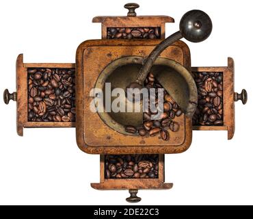 Ancien moulin à café manuel en métal et bois avec grains de café rôtis et quatre tiroirs, isolé sur fond blanc. Vue de dessus. Italie. Banque D'Images