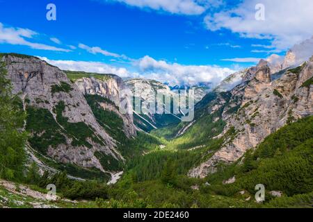 Surplombant une vallée boisée en forme de V profonde vers le spectaculaire Time Tre dans les Dolomites du nord de l'Italie Banque D'Images