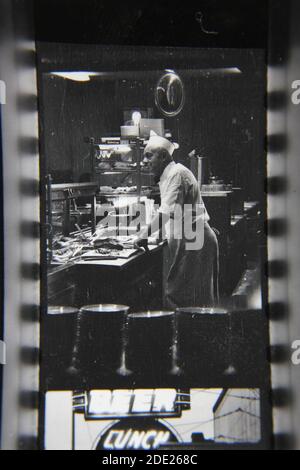 Fin années 1970 vintage noir et blanc portrait d'une courte commande cuisine de cuisinier dans la cuisine. Banque D'Images