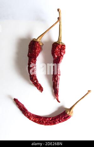 Émoticone gai composé de piments rouges sur fond blanc. Banque D'Images