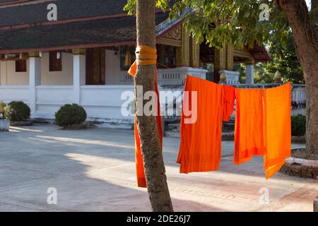 Les moines bouddhistes orange robes séchage sur les lignes de lavage au monastère Au Laos Banque D'Images