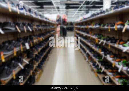 beaucoup de chaussures sur les étagères sont dans le magasin de chaussures, flou et défoqué Banque D'Images