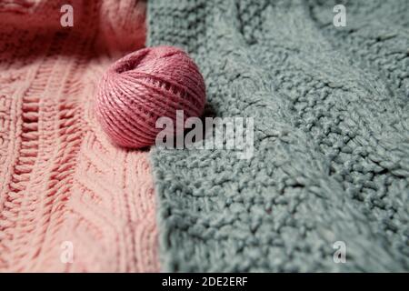 boule de laine rose sur pull gris et rose Banque D'Images
