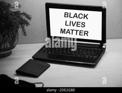 Les vies noires comptent du texte sur l'écran blanc de l'ancien ordinateur portable avec un message. Concept BLM noir et blanc. Banque D'Images