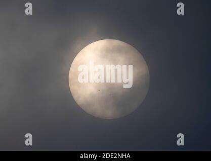 Londres, Royaume-Uni. 28 novembre 2020. Le nuage et la brume de l'après-midi créent un filtre à travers lequel une tache de soleil massive est visible sur un soleil nuageux. Ce spot solaire, AR2786, le plus grand depuis des années et plusieurs fois le diamètre de la planète Terre est une source potentielle de fusées éclairantes solaires de classe M. Le plus petit sunpot à droite est AR2785. Crédit : Malcolm Park/Alay Live News. Banque D'Images