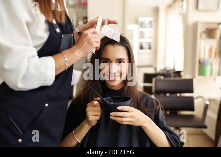 Coiffeur fait la coiffure à la cliente féminine Banque D'Images