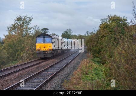 Services ferroviaires directs locomotives de classe 66 transportant un rail de réseau Train de traitement de la tête de chemin de fer ( RHTT ) traitant des feuilles d'automne Banque D'Images