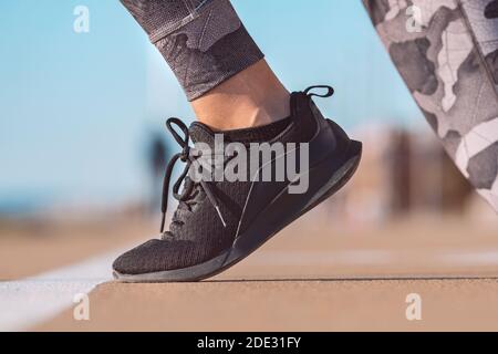 Chaussure de course à pied de l'athlète féminine sur la ligne de départ de une piste de stade Banque D'Images