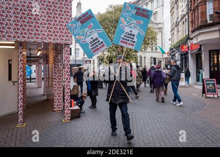 Londres, Royaume-Uni. 28 novembre 2020. Un manifestant anti-verrouillage porte des signes à travers Carnaby Street. L'Angleterre devrait se retirer du confinement le 2 décembre, alors que la pandémie du coronavirus se poursuit. Credit: Stephen Chung / Alamy Live News Banque D'Images