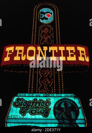Les néons et autres lumières colorées ont fait ressortir ce panneau extérieur pour le Frontier Hotel and Casino la nuit le long de Las Vegas Boulevard, mieux connu sous le nom de Strip, une route bordée d'hôtels et de casinos spectaculaires, juste au sud des limites de la ville de Las Vegas, Nevada, États-Unis. Le Stardust a ouvert ses portes en 1942 et a fonctionné pendant 65 ans dans cette destination célèbre du désert, bien connue pour ses jeux de hasard et ses bons moments. Cette photographie historique a été prise en 1983 avant la démolition de la frontière en 2007. Le panneau annonce les artistes vedettes de la salle d'exposition de l'hôtel, les magiciens Siegfried et Roy.