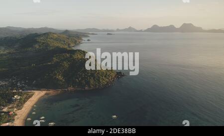 Paradise Resort à Tropic Island Aerial. Forêts vertes dans les montagnes de la campagne des Philippines. Navires et bateaux à Ocean Bay eau peu profonde. Plage de sable avec des montagnes tropicales boisées dans des cottages, maisons Banque D'Images