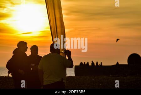 Brighton Royaume-Uni 28 novembre 2020 - les foules apprécient le coucher du soleil en fin d'après-midi et la murmure étoilée sur la plage et le front de mer de Brighton, tandis qu'une belle journée d'automne chaude se termine sur la côte sud : Credit Simon Dack / Alamy Live News Banque D'Images